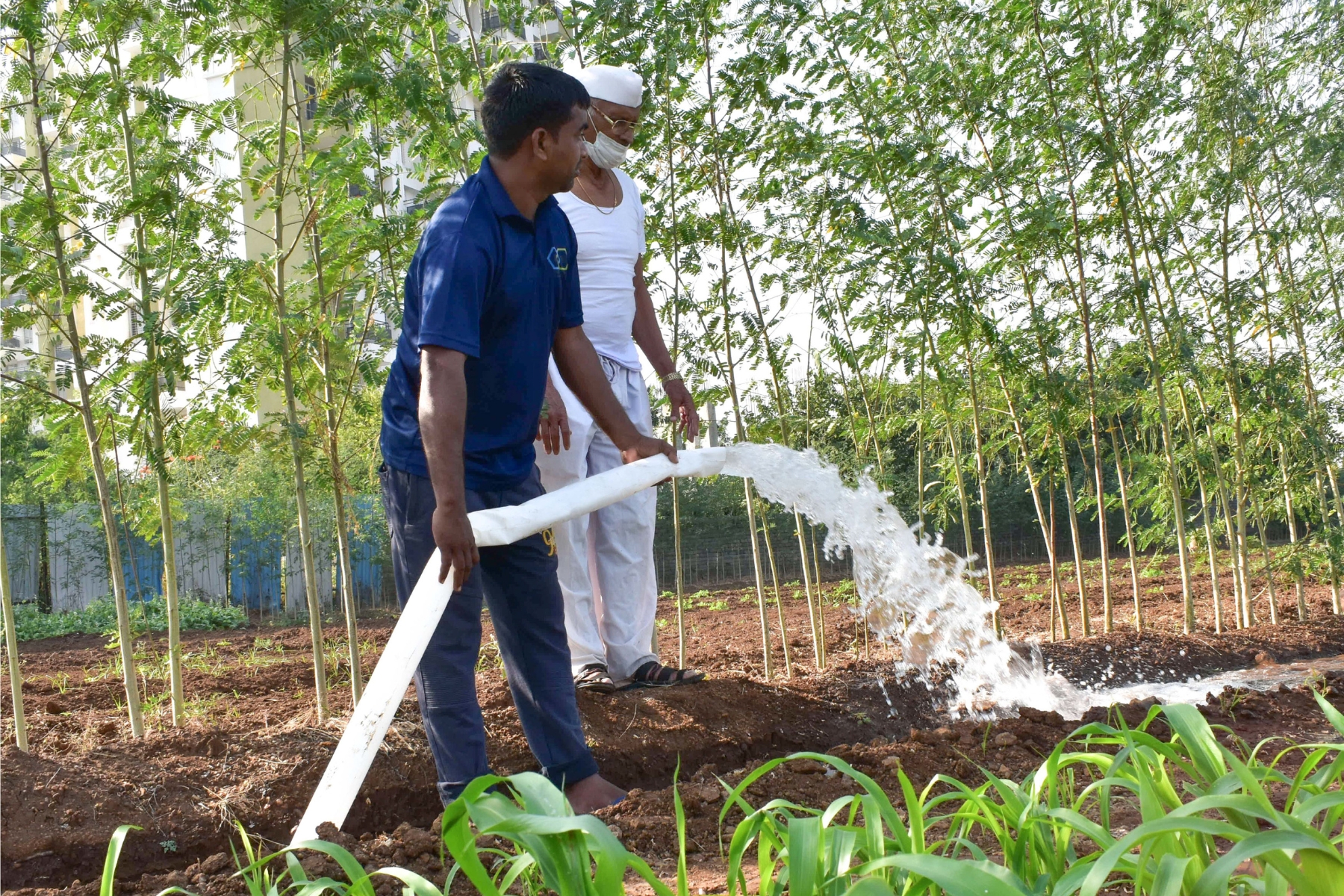 Farmers using MIPATEX HDPE woven lay flat hose for irrigation and water delivery in agricultural fields